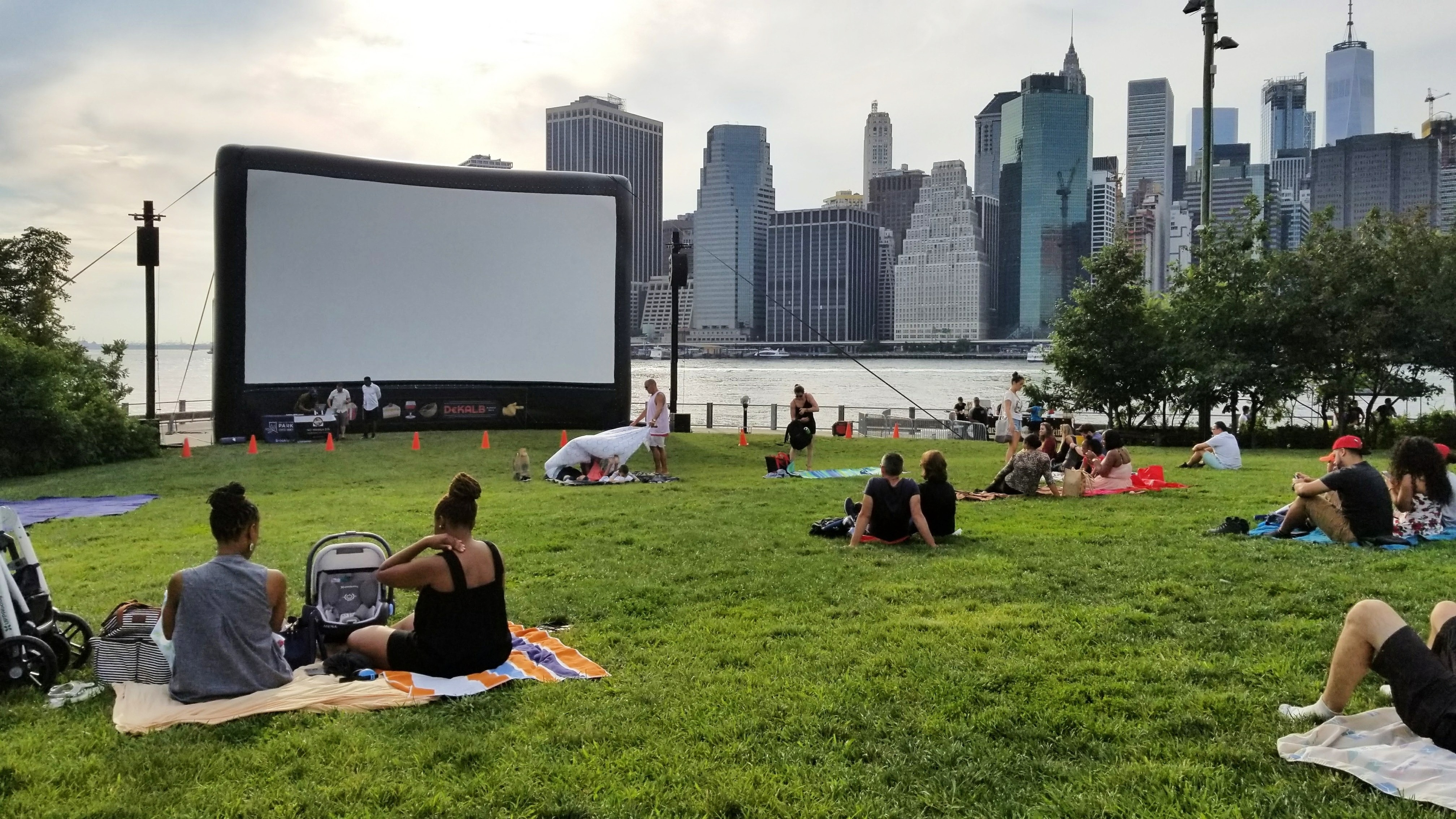 Community outdoor movie screening with families enjoying together on blankets
